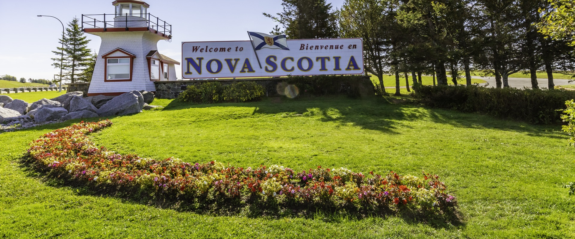 At the visitor information centre in Amherst, there is a lighthouse on the right hand side and in the center there is a sign that says 'Welcome to Nova Scotia'