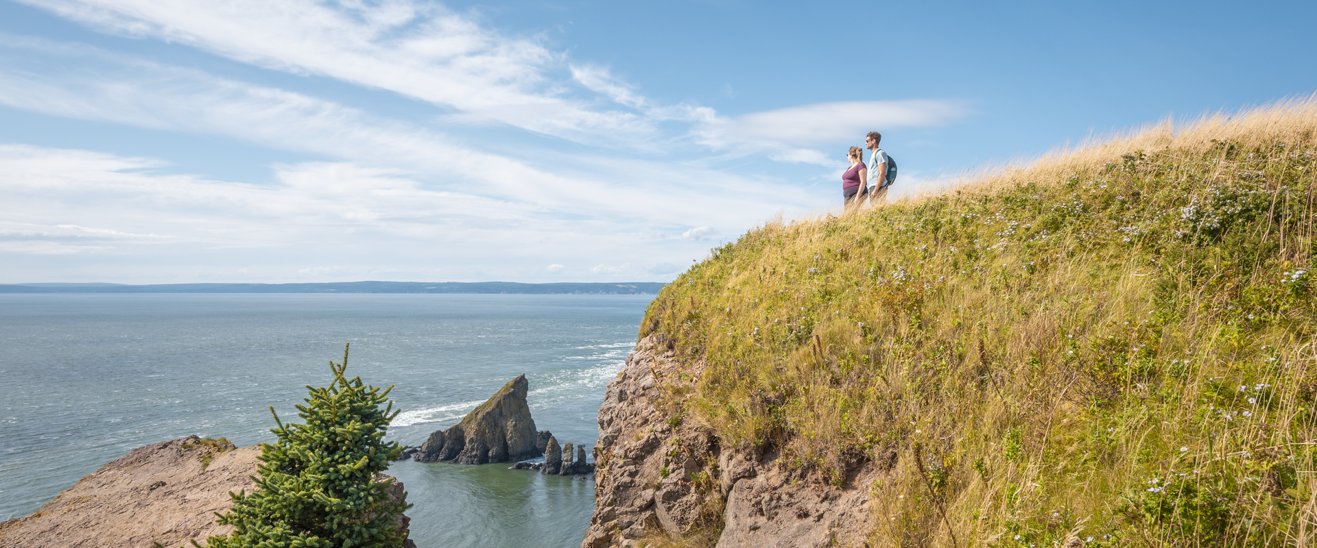 Two people standing at the point on Cape Split. 