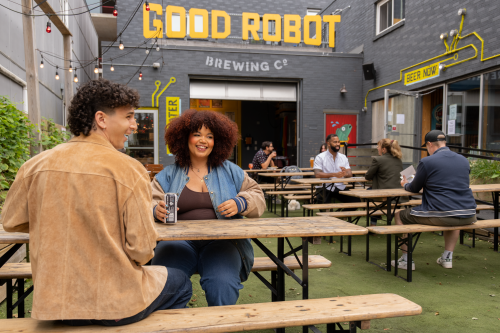 Outside shot of the Good Robot patio on Robie Street. There are people sitting at tables. 
