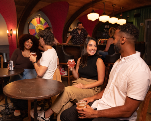 Guests having a conversation over a table at Good Robot Brewing Company. 