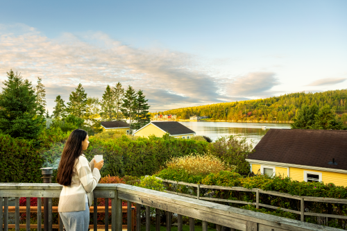 Woman drinking coffee overlooking the view at Wilson's Coastal Club