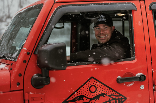 Owner and operator, Mac Graham, smiles from his Jeep. 