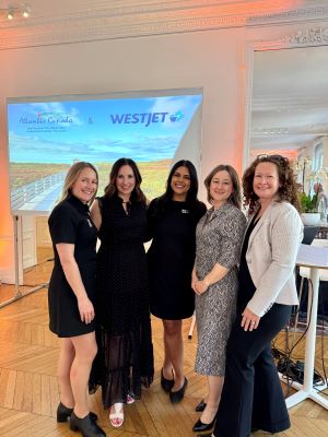 A group of five people standing together in front of a presentation about Atlantic Canada. 