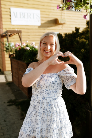Stephanie Wessoleck makes a heart shape with her hands outside Albert's Inn. 