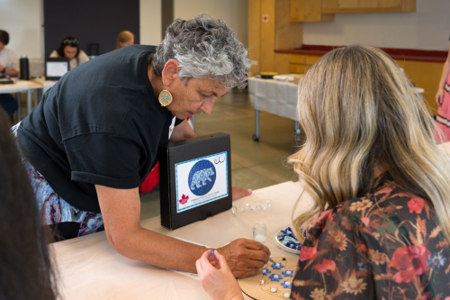 Artist and owner, Melinda Robertson teaches a guest how to build their mosaic. 