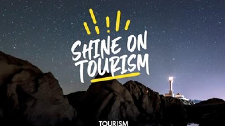 Image of Cape Forchu Lighthouse at night with Shine On Tourism logo