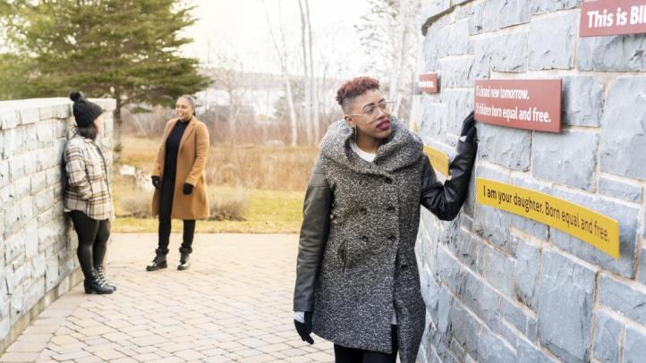 Woman looking at outdoor exhibit at Black Loyalist Heritage Centre