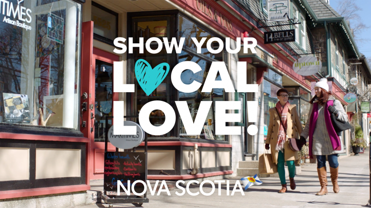 Two women walking past shops carrying shopping bags. Text says Show Your Local Love Nova Scotia