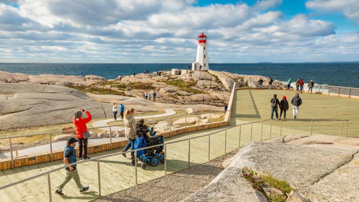People, including a person in a wheelchair, on the accessible viewing deck at Peggy's Cove.