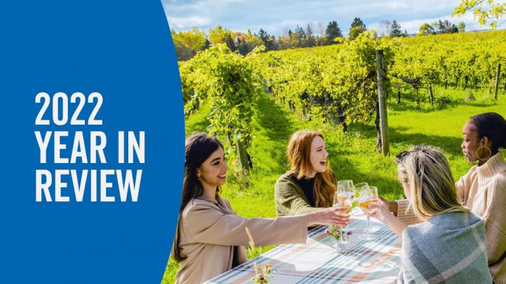 Four women toasting with wine glasses in a vineyard. Text reads 2022 Year in Review