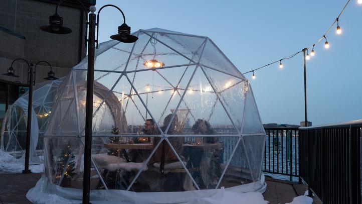 People enjoying a domed dining experience in wintertime in Nova Scotia