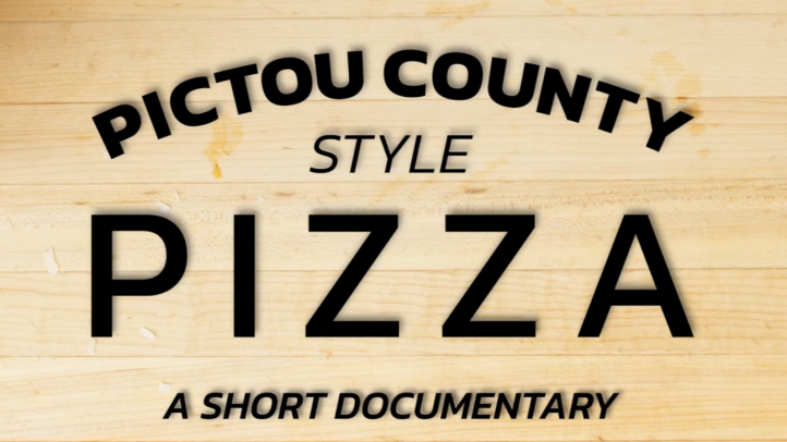 A cutting board with the text Pictou County Style Pizza A Short Documentary