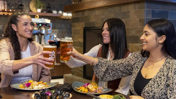 People sitting at a table at Kiju's Restaurant raise a glass to toast. 