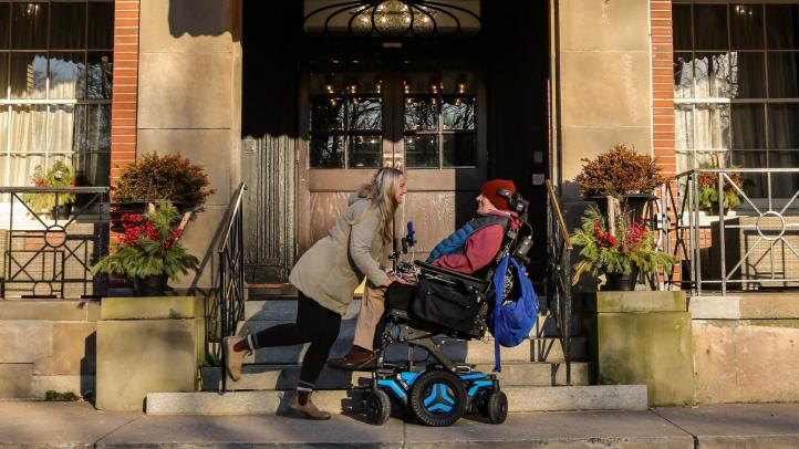 Two people in front of the Lord Nelson Hotel in winter. 