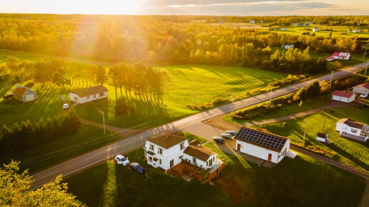 A rural road with houses as the sun is setting