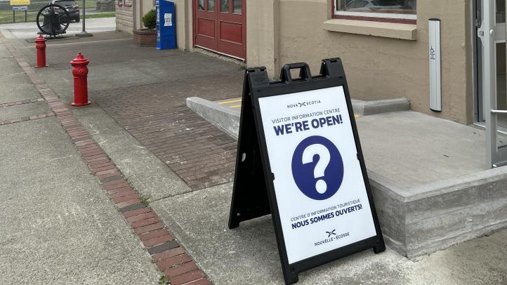 A blue and while open sign in front of a ramp
