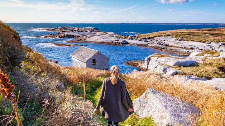 A person standing on the edge of the ocean on Sambro Island. 