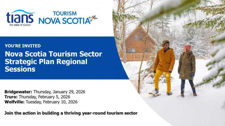 Two people standing in the snow with a brown cabin in the background