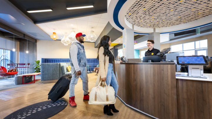 Two people checking in to Tru by Hilton Yarmouth