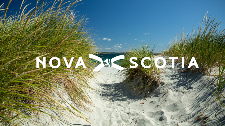 A path through a dune to the beach with a Nova Scotia logo over it. 