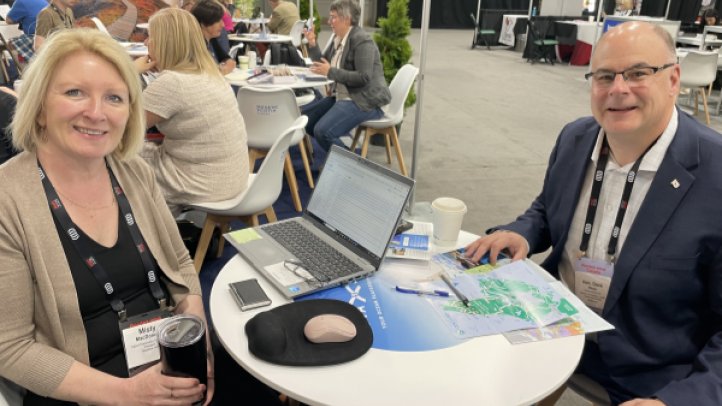 Minister Dave Ritcey joins the NS delegation at RVC in Winnipeg. Two people seated at a table for two for a business meeting at a conference. 