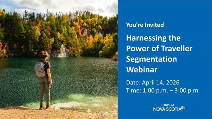 A person standing back to looking at a lake