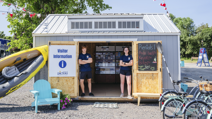 Community information centre at Pictou Waterfront. Two people standing in the doorway and looking at the camera. 