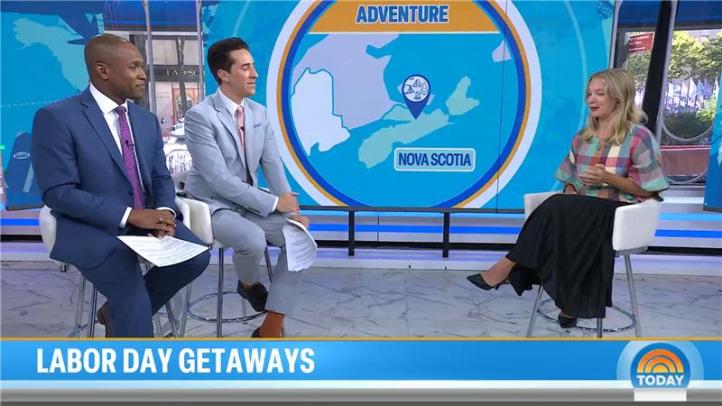 Three people siting on chairs in front of a big screen with a Nova Scotia map
