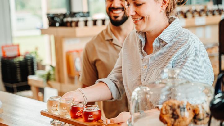 Two people standing at a food counter retrieving their items 