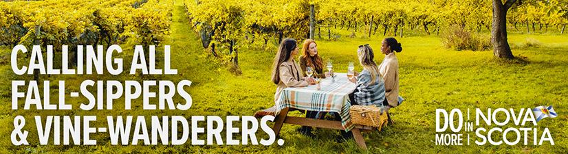 Digital billboard ad showing a group of women dining at a table in a vineyard. Text reads: Calling all fall-sippers and vine-wanderers.