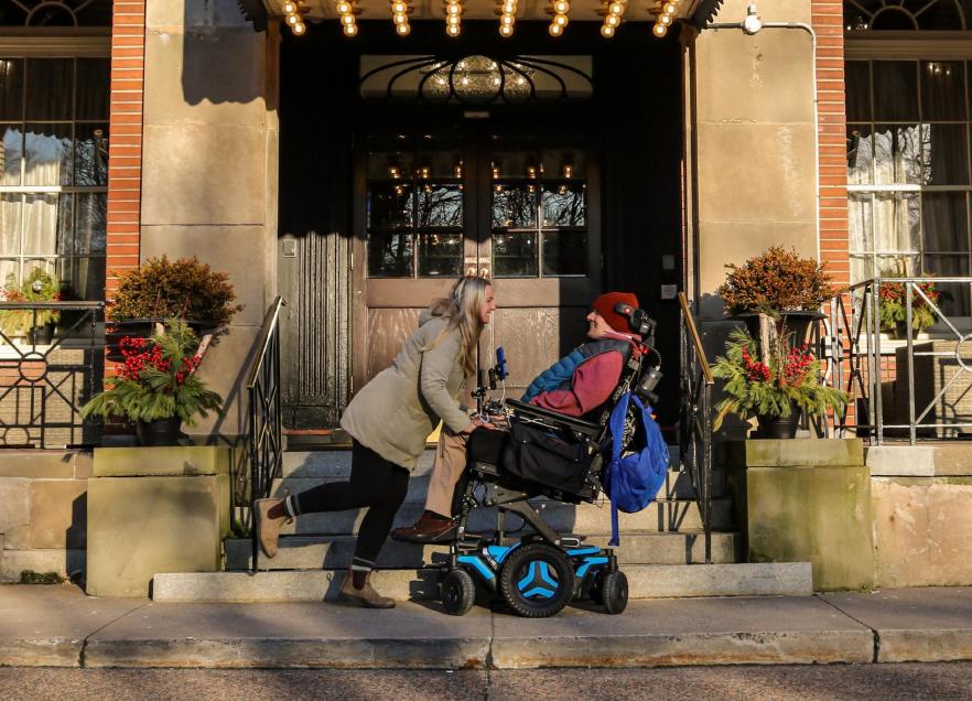 Two people in front of the Lord Nelson Hotel in winter. 