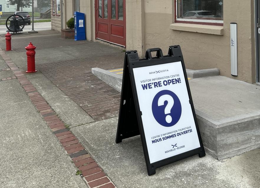 A blue and while open sign in front of a ramp
