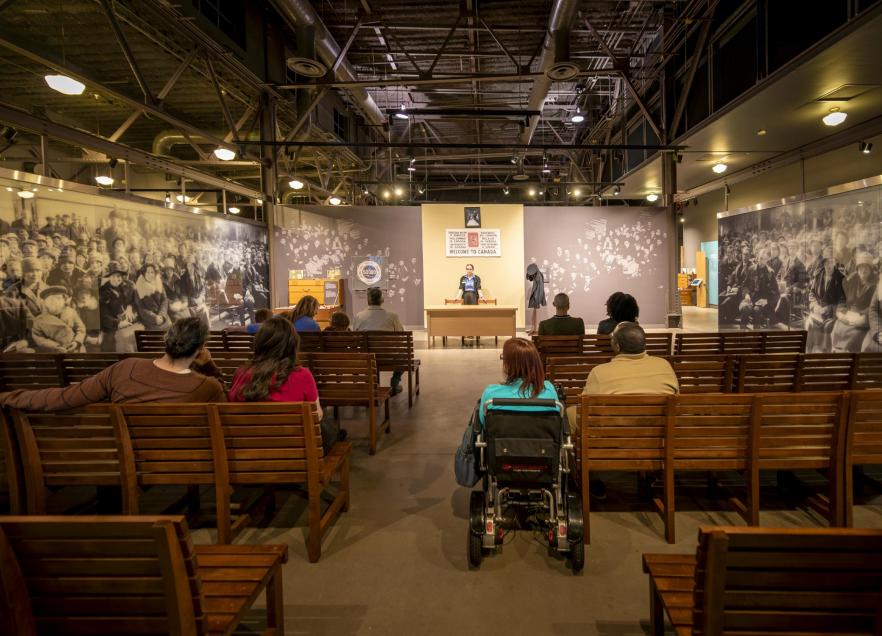 People listening to a presentation in a theatre in the Museum at Pier 21. 
