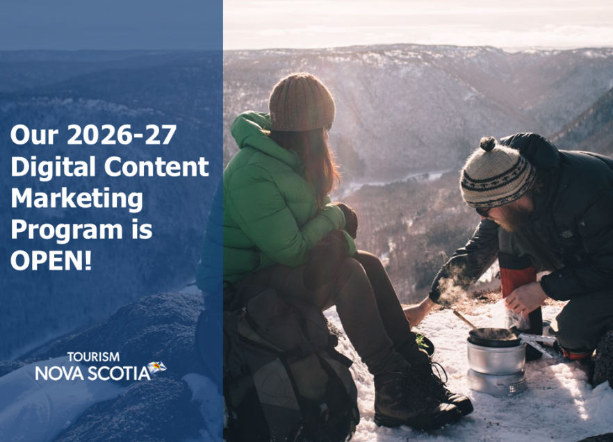 Two people on a snowy hilltop making a fire. 