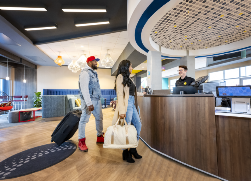 Two people checking in to Tru by Hilton Yarmouth