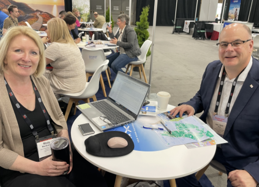 Minister Dave Ritcey joins the NS delegation at RVC in Winnipeg. Two people seated at a table for two for a business meeting at a conference. 