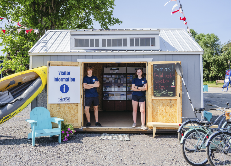 Community information centre at Pictou Waterfront. Two people standing in the doorway and looking at the camera. 